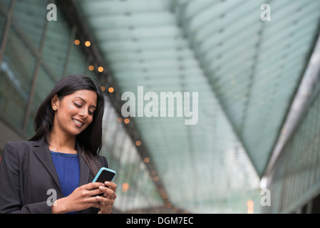 Business people. A young woman in a blue dress and grey jacket. Stock Photo