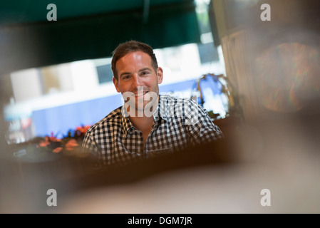 Business people. A man seated at a table in a bar or cafe. Stock Photo