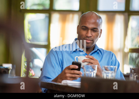 Business people. A man sitting checking his phone. Stock Photo