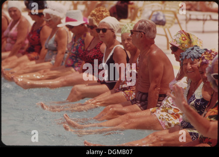 This image shows residents of Century Village Retirement Community participating in a daily exercise session around the pool. The activity promotes health and social engagement among the elderly residents. Stock Photo