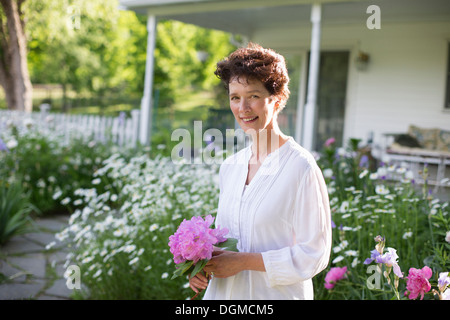 Organic farm. Summer party. A woman holding a bunch of flowers. Stock Photo
