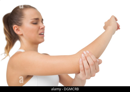 Suffering young woman touching her sore elbow Stock Photo