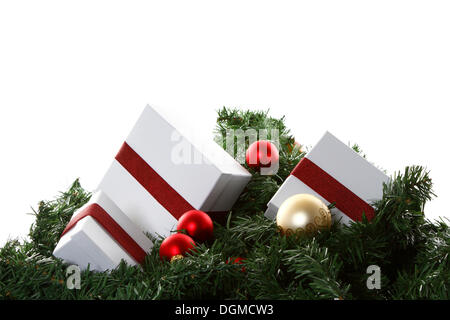Christmas presents and baubles on artificial fir sprigs Stock Photo