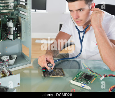 Handsome stern computer engineer holding stethoscope Stock Photo