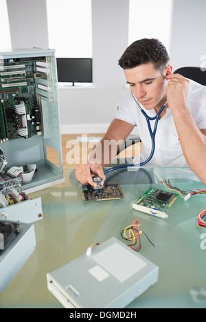Handsome serious computer engineer holding stethoscope Stock Photo