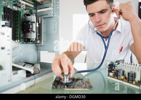 Handsome focused computer engineer holding stethoscope Stock Photo