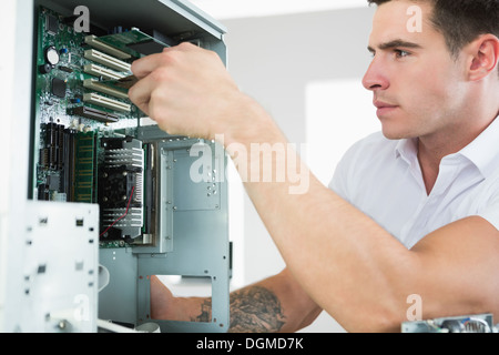 Handsome frowning computer engineer working at open computer Stock Photo