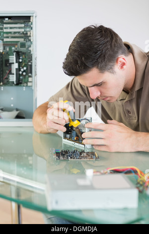Handsome focused computer engineer repairing hardware with pliers Stock Photo
