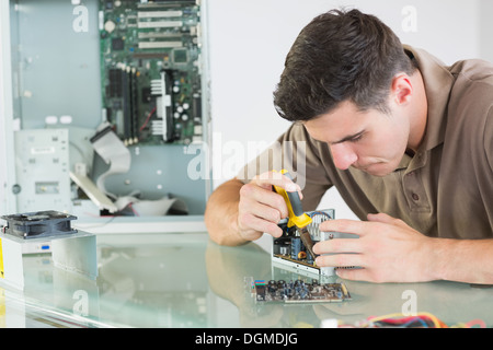 Handsome serious computer engineer repairing hardware with pliers Stock Photo