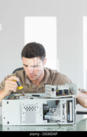 Handsome serious computer engineer repairing open computer Stock Photo