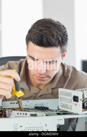 Handsome focused computer engineer repairing open computer Stock Photo
