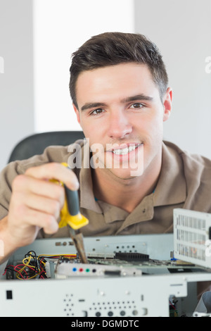 Handsome happy computer engineer repairing open computer Stock Photo