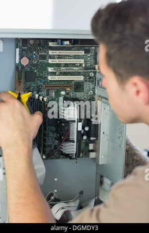 Computer engineer repairing open computer with pliers Stock Photo