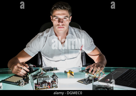 Handsome stern computer engineer working by night Stock Photo
