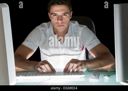 Handsome stern computer engineer working at night Stock Photo