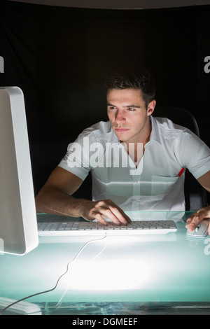 Handsome concentrating computer engineer working at night Stock Photo