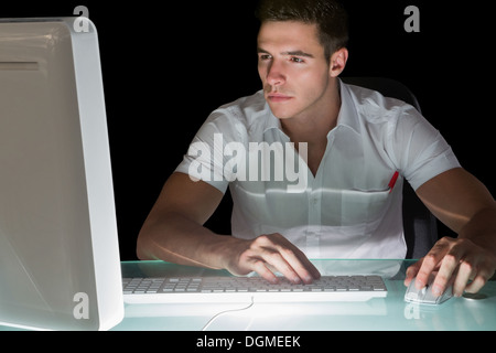 Handsome focused computer engineer working at night Stock Photo