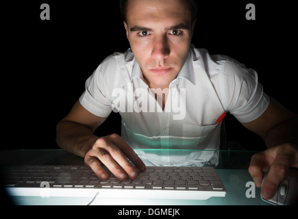 Handsome serious computer engineer working at night Stock Photo