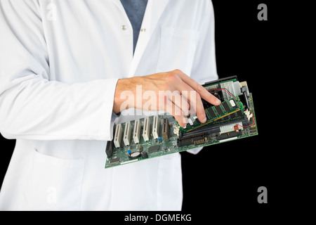 Close up of computer engineer holding hardware at night Stock Photo