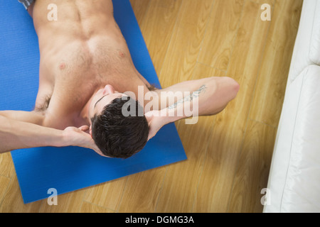 Overhead view of attractive man doing sit ups Stock Photo