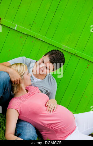 Pregnant woman lying in the arms of her husband Stock Photo