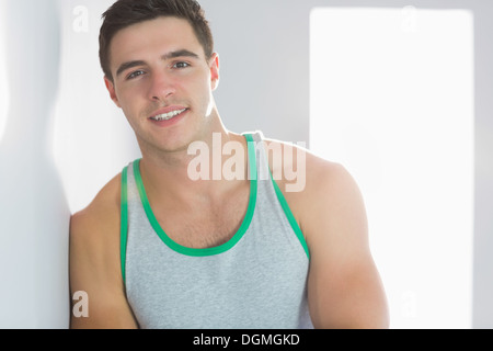 Smiling handsome man leaning against wall Stock Photo