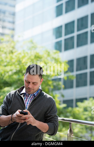Summer. Business people. A man checking his smart phone for messages. Stock Photo