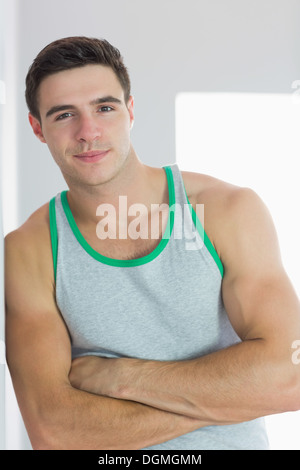 Smiling handsome man leaning arms crossed against wall Stock Photo