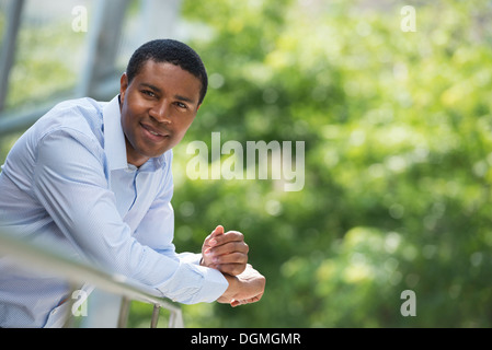 Summer. Business people. A man leaning on a railing relaxing. Off grid. Stock Photo