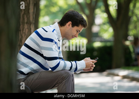 Summer. Business people. A man checking his smart phone for messages. Stock Photo