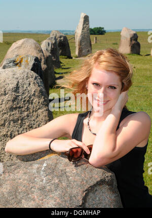 Redhaired woman at the Ale's Stones or Ales stenar near Kåseberga, Sweden, Europe Stock Photo