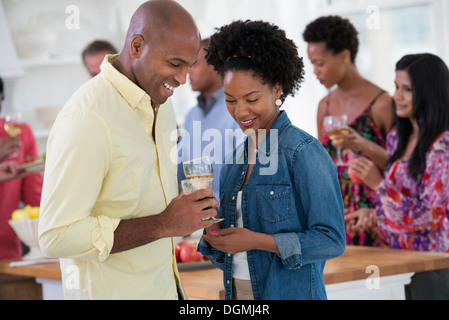 Networking party or informal event. A man and woman, with a crowd around them. Stock Photo