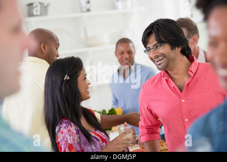 A networking office party or informal event. A man and woman at the centre of a group. Stock Photo