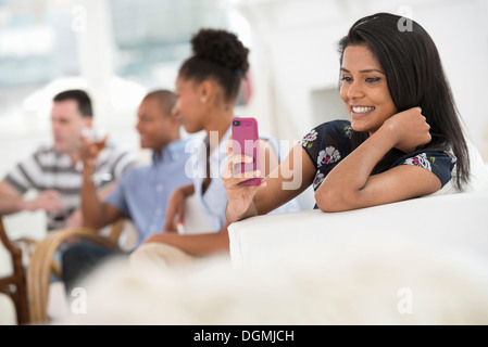 Office event. A woman using her pink smart phone. Stock Photo