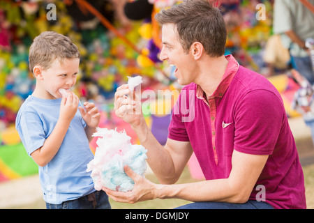 USA, Utah, Salt Lake City, Happy father with son (4-5) in amusement park eating cotton candy Stock Photo