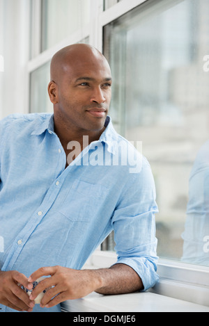 Business people. A man with a glass of wine looking out of the window. Stock Photo