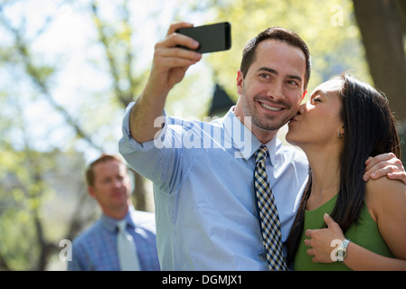 A businesswoman and two businessmen outdoors in the city. Stock Photo