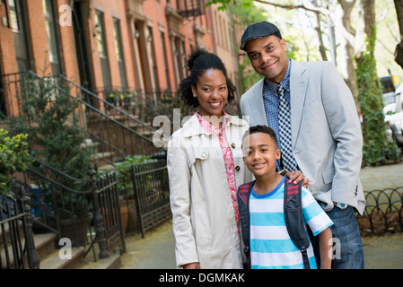 A family outdoors in the city. Two parents and a young boy walking together. Stock Photo
