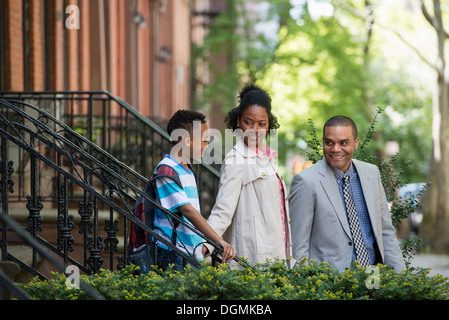 A family outdoors in the city. Two parents and a young boy walking together. Stock Photo