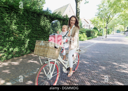 Netherlands, South Holland, Oud-Beijerland, Mother with her baby daughter (12-17 months) on bicycle Stock Photo