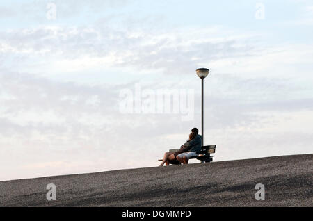 Young lovers sitting on a bench on the dike, Westkapelle, Walcheren, Zeeland, Netherlands, Benelux, Europe Stock Photo
