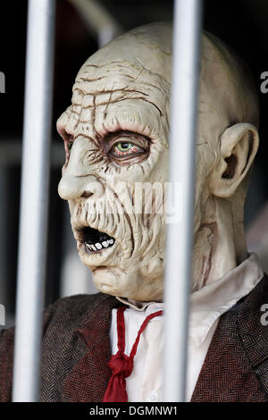 Man behind bars, desperate face, haunted house figure Stock Photo