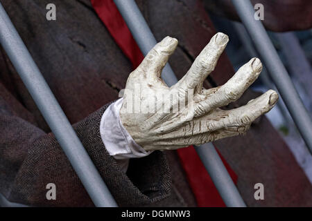 Hand reaching through prison bars, haunted house figure Stock Photo