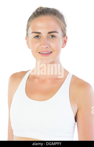 Attractive smiling blonde wearing sports bra looking at camera Stock Photo