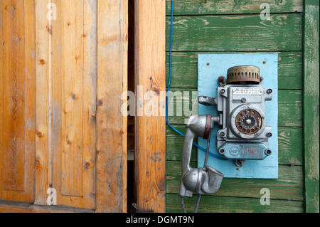 Old phone on the building entrance to the Port Authority in the Russian mining settlement of Barentsburg, Isfjorden, Spitsbergen Stock Photo