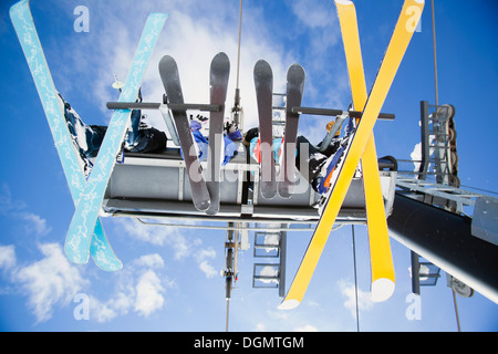 Family of skiers on ski lift seen from below Stock Photo