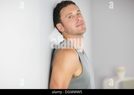 Sporty handsome man leaning against wall Stock Photo