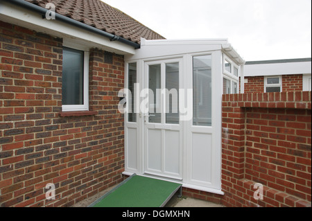 Ramp for the disabled coated with a non slip surface by front door of property leading into a double glazed porch Stock Photo