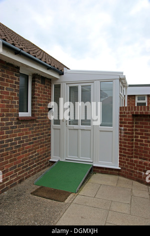 Ramp for the disabled coated with a non slip surface by front door of property leading into a double glazed porch Stock Photo