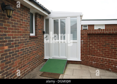 Ramp for the disabled coated with a non slip surface by front door of property leading into a double glazed porch Stock Photo